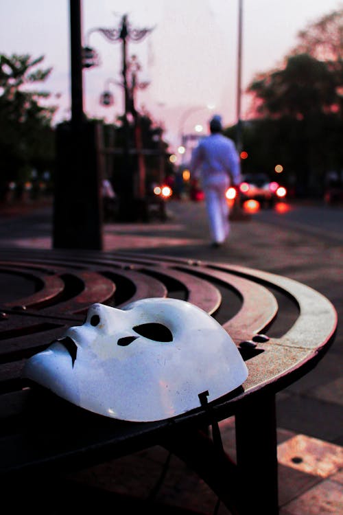 Selective Focus Photography of White Mask on Brown Table