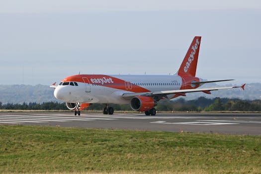 EasyJet airplane taxiing on runway at Bristol Airport on a clear day.