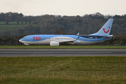 TUI airplane taxiing on the runway at a scenic airport.