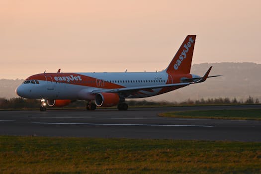 EasyJet plane on runway during sunset, showcasing vivid colors and travel theme.