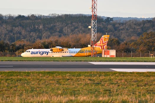 Aurigny Airlines aircraft on a runway surrounded by lush landscape at Bristol Airport.