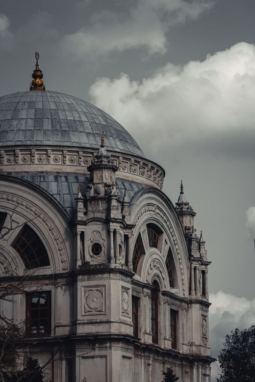 Free A close-up of a historic mosque dome nestled in Istanbul's skyline under cloudy skies. Stock Photo