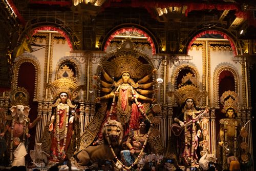 Free Detailed Durga Puja idol with deities in traditional attire, vibrant festival decor. Stock Photo