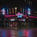夜晚，得梅因酒吧外霓虹闪烁，活力四射，展现了城市夜生活的魅力