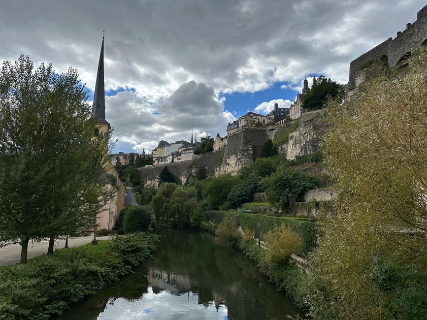 Scenic view of Luxembourg's historic fortifications and lush greenery along the Alzette River.