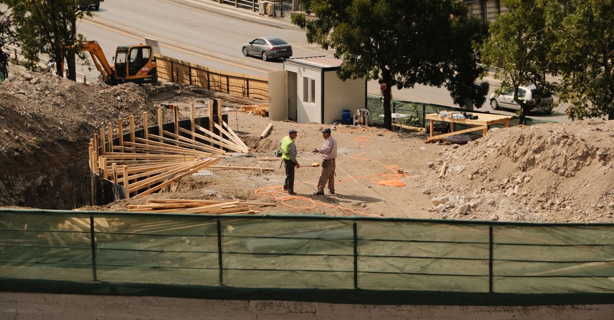Construction manager reviewing blueprints on a Toronto pre-construction site, showing why a building delay can be beneficial