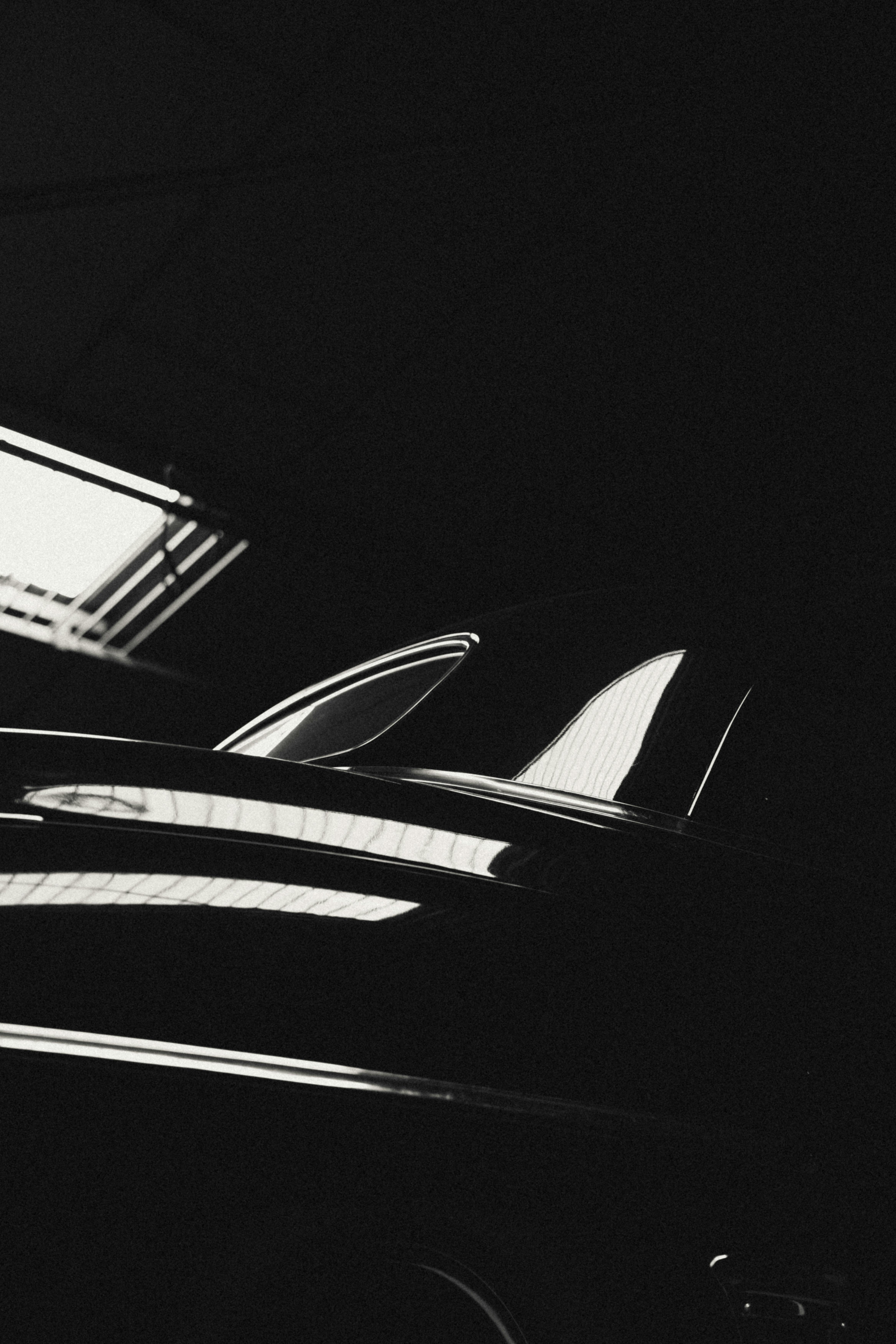 Gratis Silueta en blanco y negro de un coche clásico con llamativos reflejos reflectantes, que irradia elegancia. Foto de stock