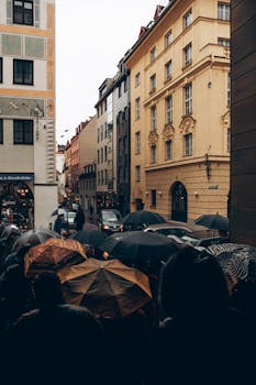 Crowded urban street scene with people holding umbrellas on a rainy day.