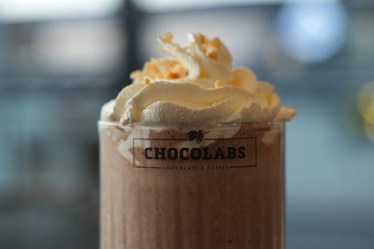 Indulge in a delicious chocolate drink topped with whipped cream at ChocoLabs café.