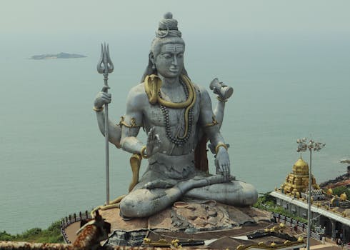 A grand statue of Lord Shiva seated, overlooking the Indian Ocean, symbolizing serenity.