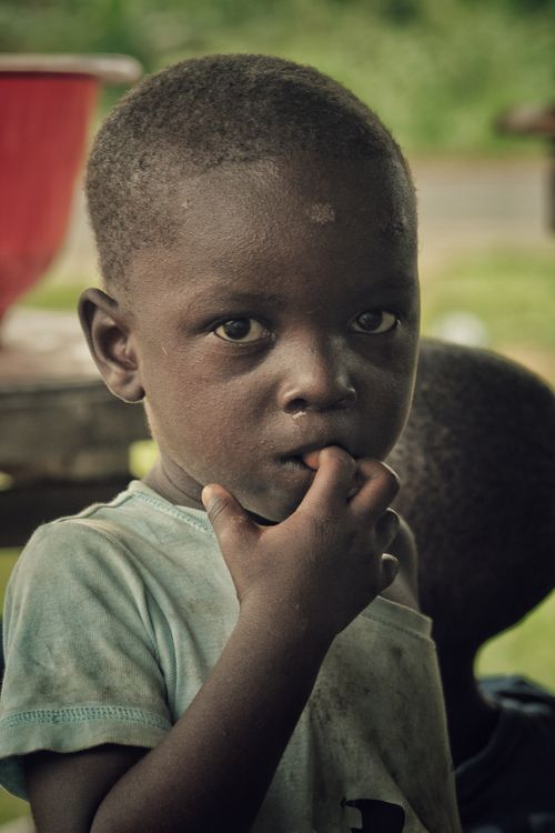 Free A contemplative child outdoors, showing curiosity and deep thoughts. Stock Photo