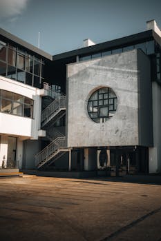 Contemporary building with a circular window and staircase, showcasing urban design.