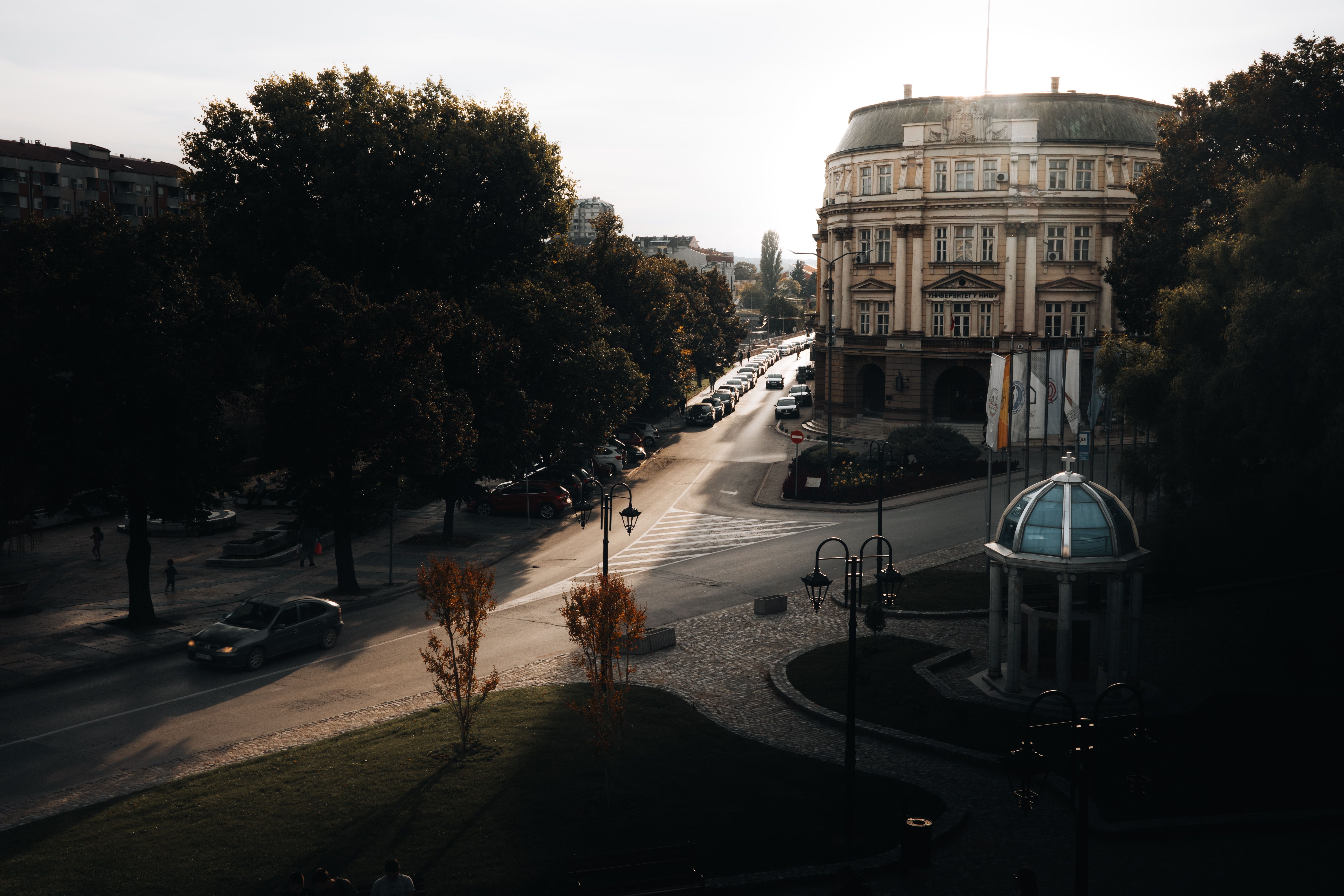 A city street view with historic architecture and soft sunset lighting creating dramatic shadows. — Trójmiasto
