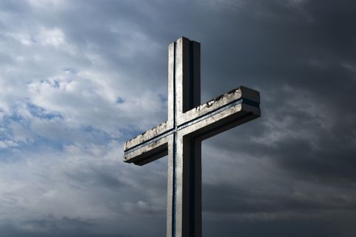 Free A solitary cross stands tall against a dramatic, cloudy sky, symbolizing faith and spirituality. Stock Photo