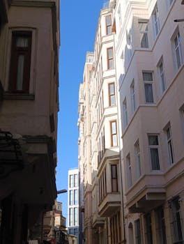 A picturesque alley showcasing tall buildings and blue sky in an urban setting.