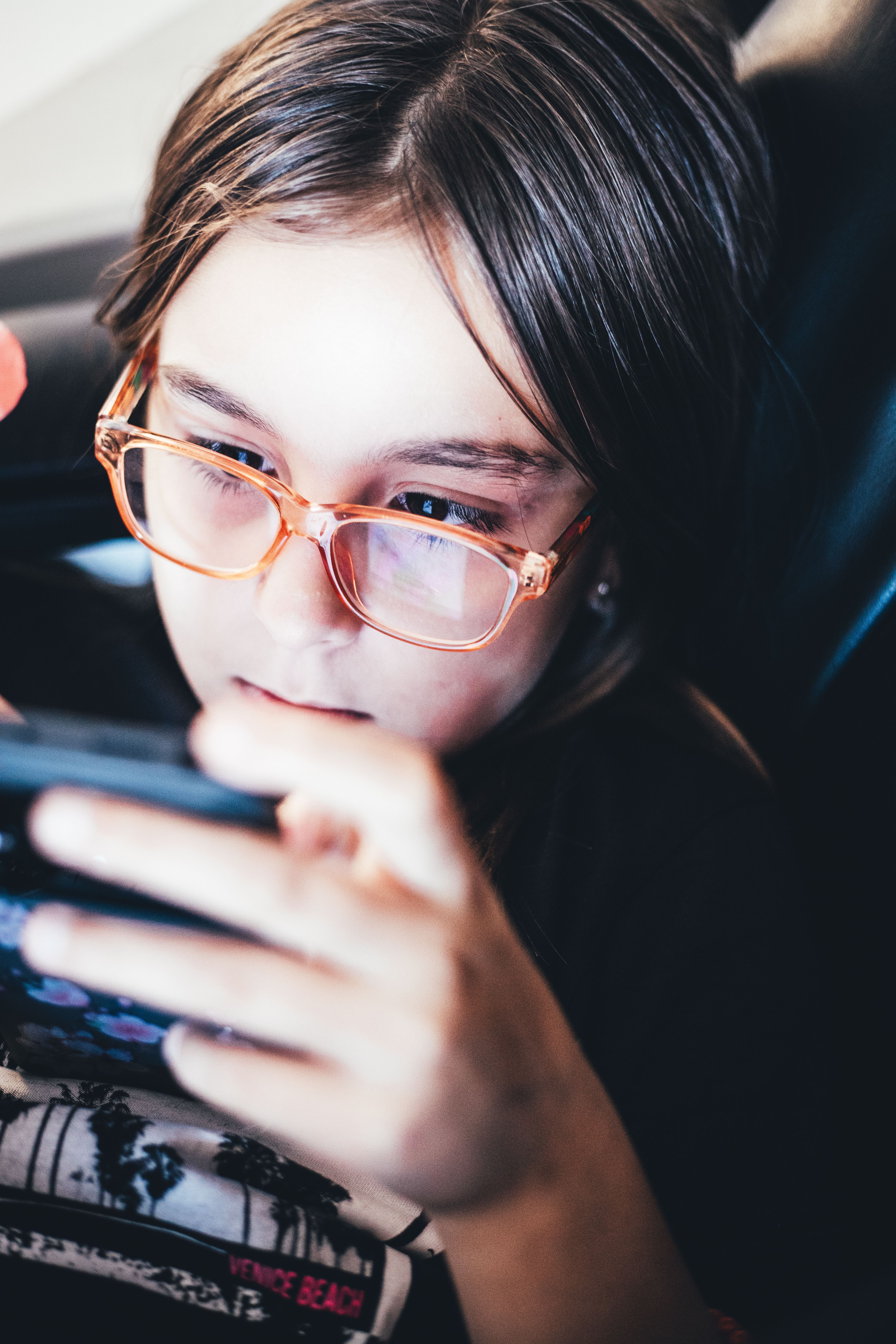 A child intensely focused on a mobile game, highlighting technology use.