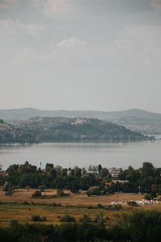 A peaceful view of Lake Balaton with distant hills under a clear sky. - Fotografer Sidoarjo