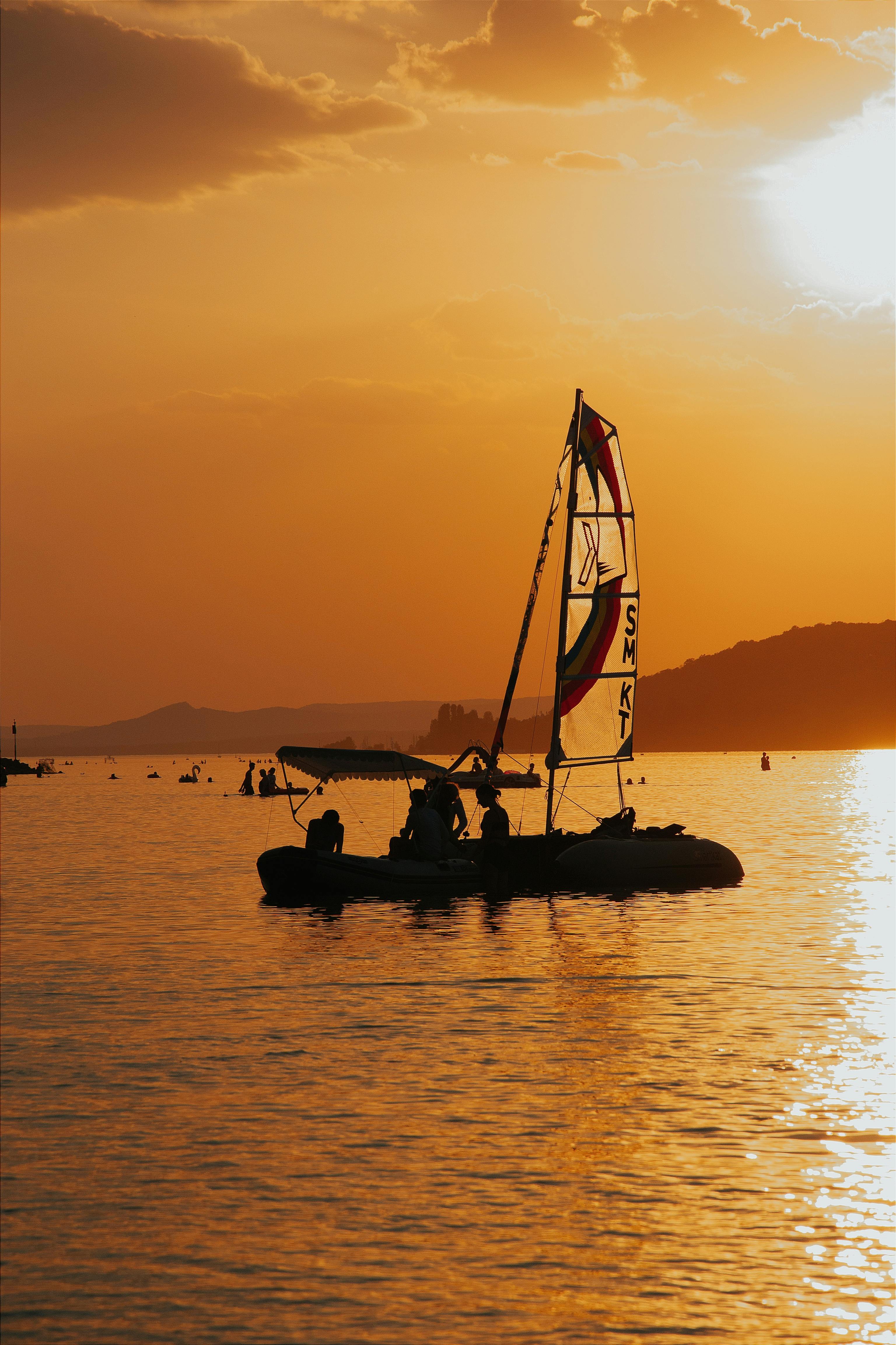 A serene sunset with people sailing on Balaton Lake, Hungary.