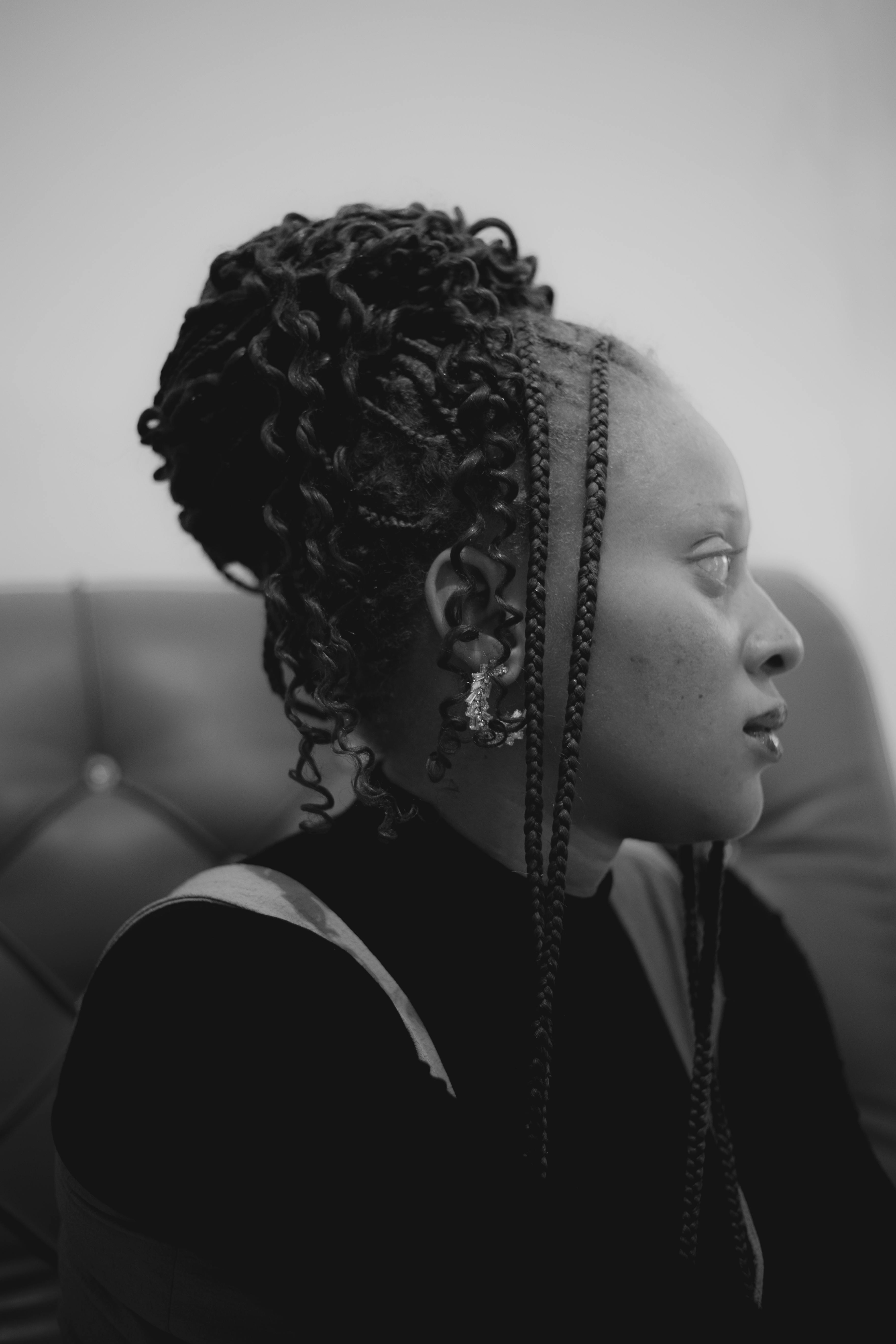 Black and white side profile of a woman with braided hair indoors.