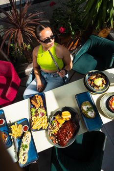 Young woman enjoys outdoor dining with a variety of dishes in England.