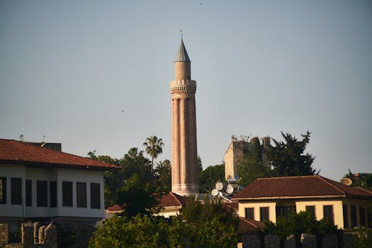 A picturesque view of the Yivli Minaret amidst traditional Ottoman architecture in Antalya.