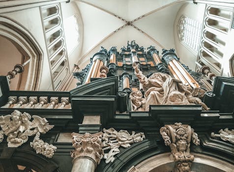 从低角度仰望，华丽的教堂风琴装饰着复杂的雕塑和天使人物，景象令人惊叹