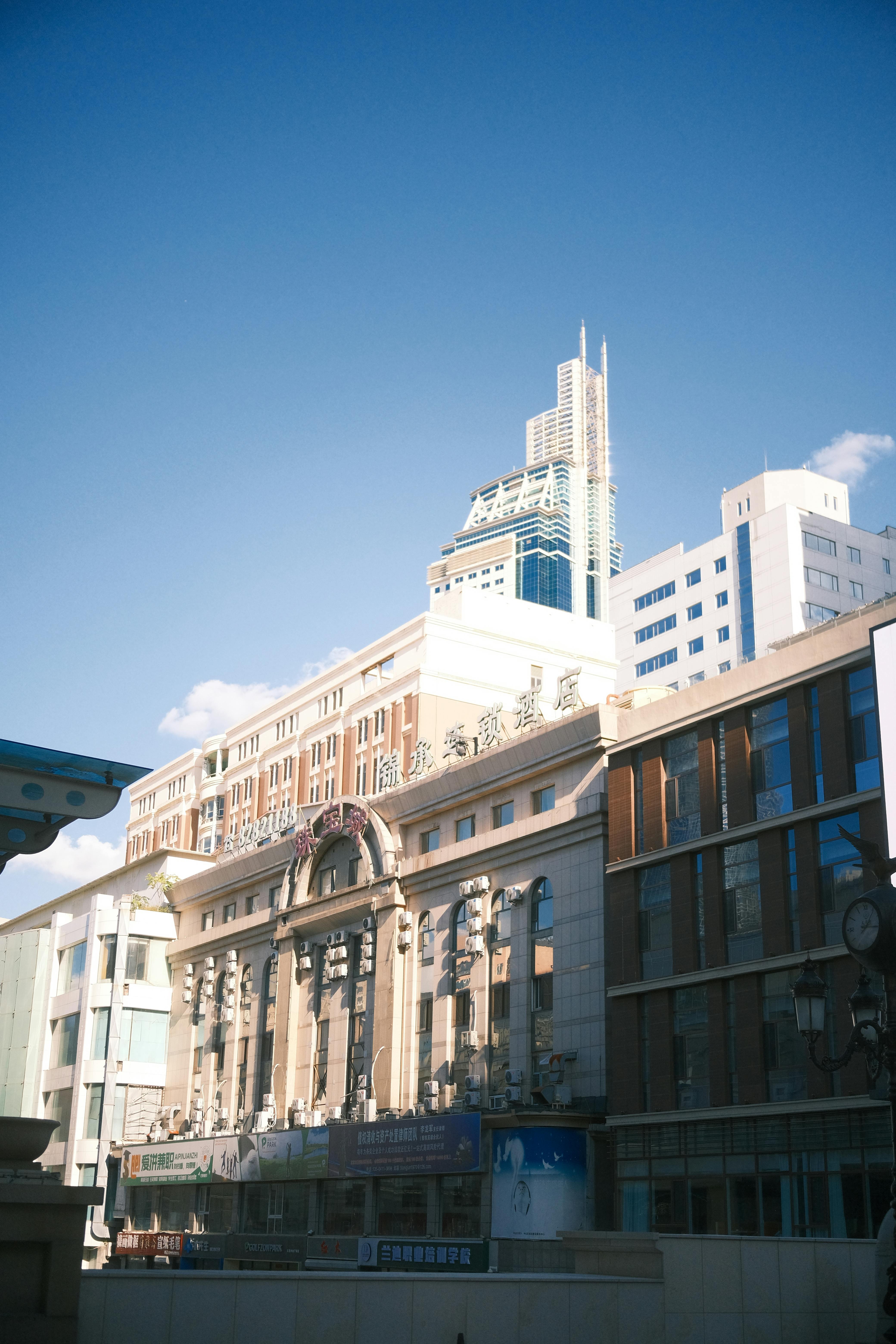 Urban cityscape showcasing modern buildings under a clear blue sky.