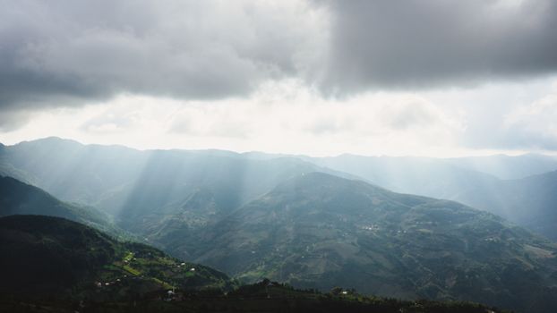 A breathtaking view of sunrays breaking through clouds over Erbaa mountains.