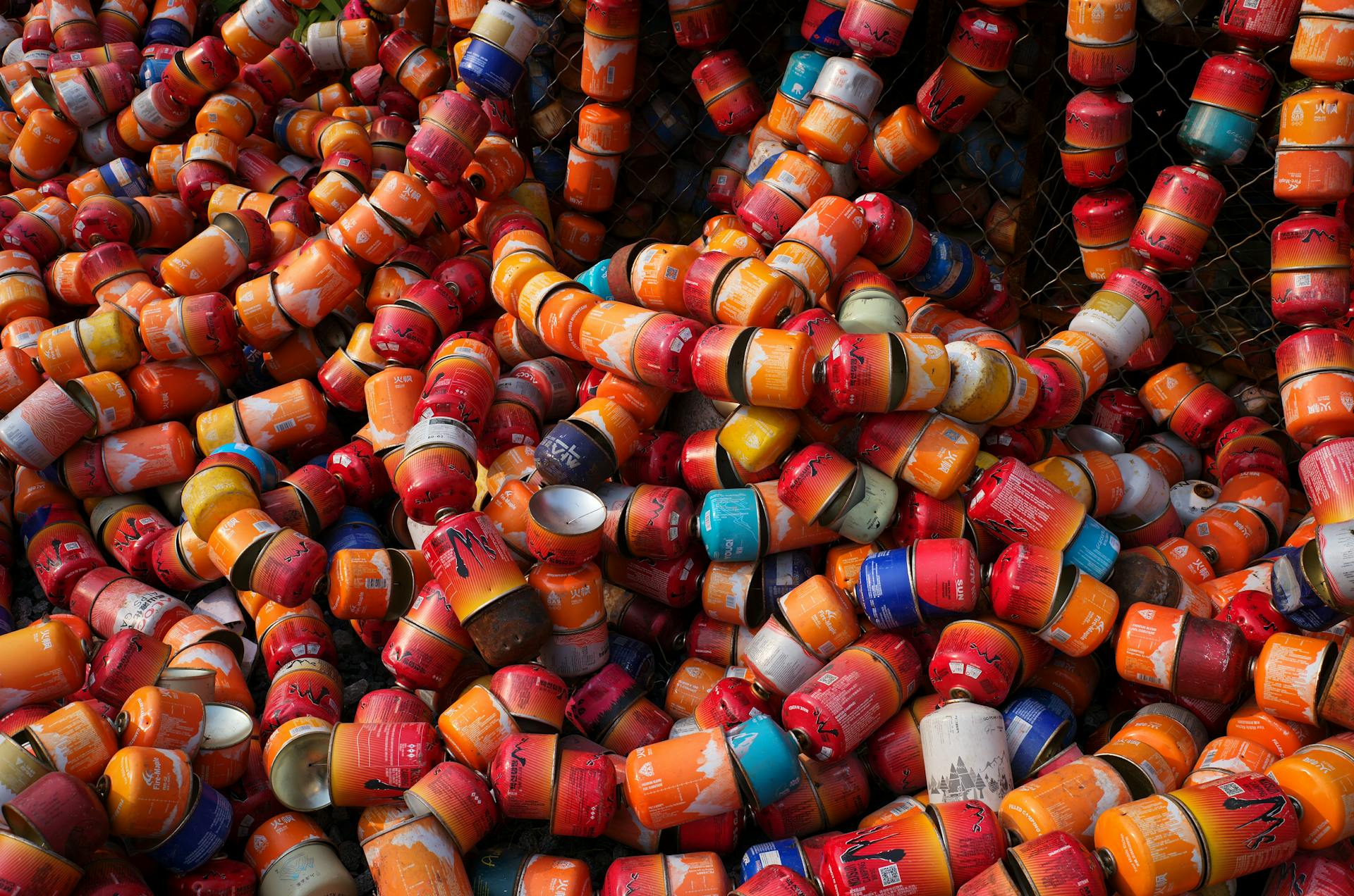 Vibrant pile of discarded metal canisters waiting for recycling process.