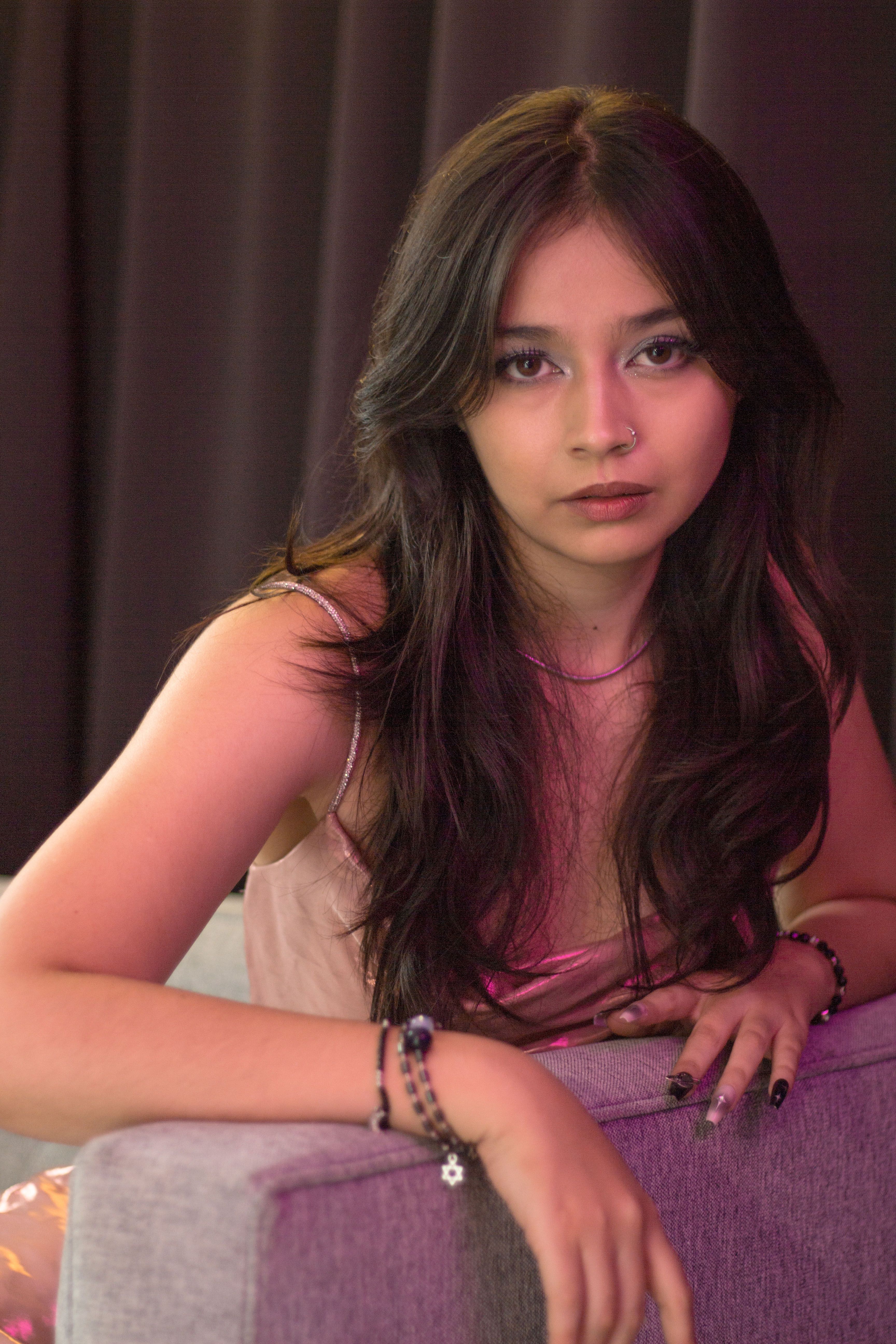 A stylish portrait of a young woman posing indoors with soft lighting.