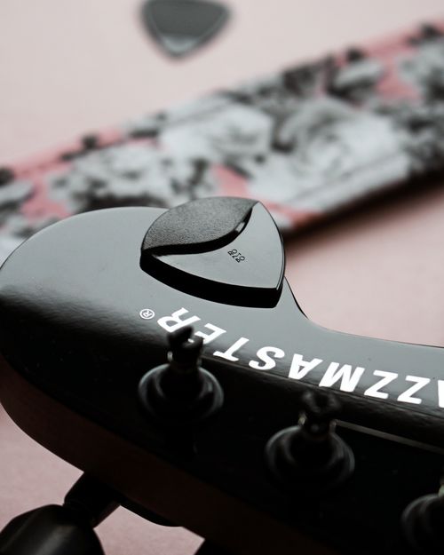 Free Black electric guitar with picks and strap in focus, ideal for music enthusiasts. Stock Photo