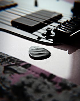 Artistic shot of a black electric guitar with a focus on the plectrum.