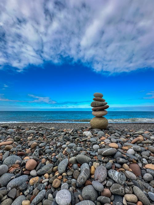 Free Balanced stones on a pebble beach in Cide, Türkiye, under a vibrant blue sky. Stock Photo