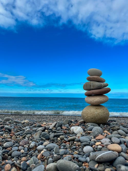 Free Balanced stones on a pebble beach with a vibrant blue sky on Cide Beach, Türkiye. Stock Photo