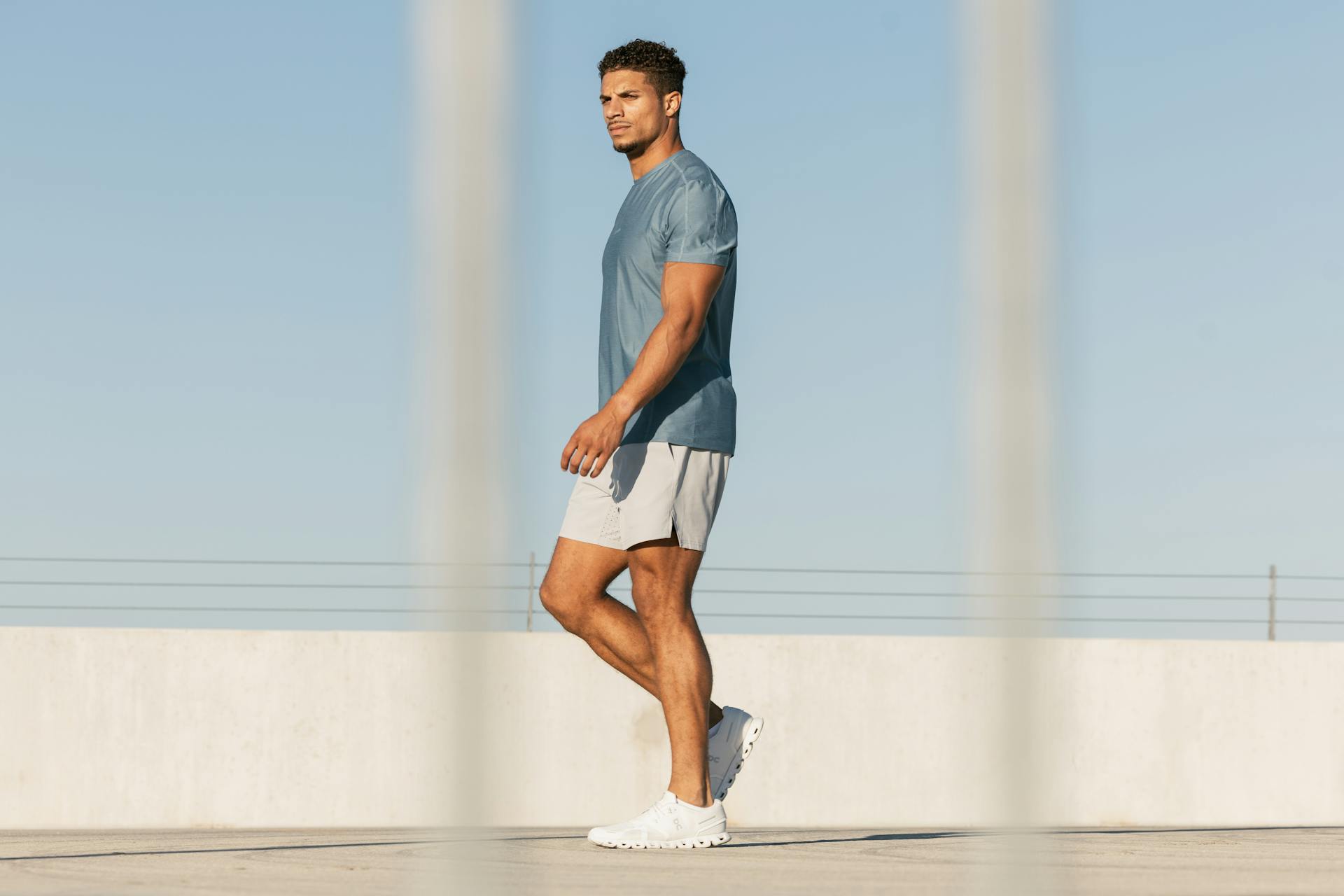 Athletic man in casual workout attire walking on a rooftop in Austin, Texas.