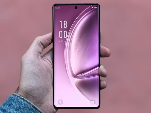 Free A person holding a sleek, modern smartphone with a purple screen against a plain background. Stock Photo