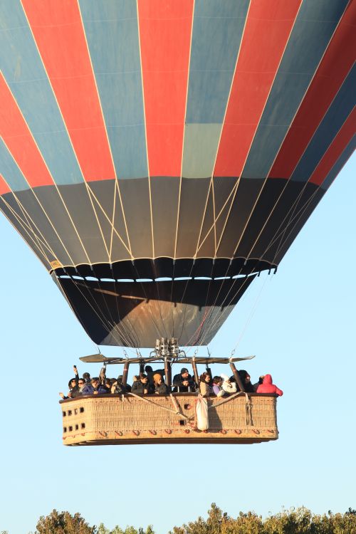Free Hot air balloon filled with people soaring over Cappadocia's scenic landscape, Turkey. Stock Photo