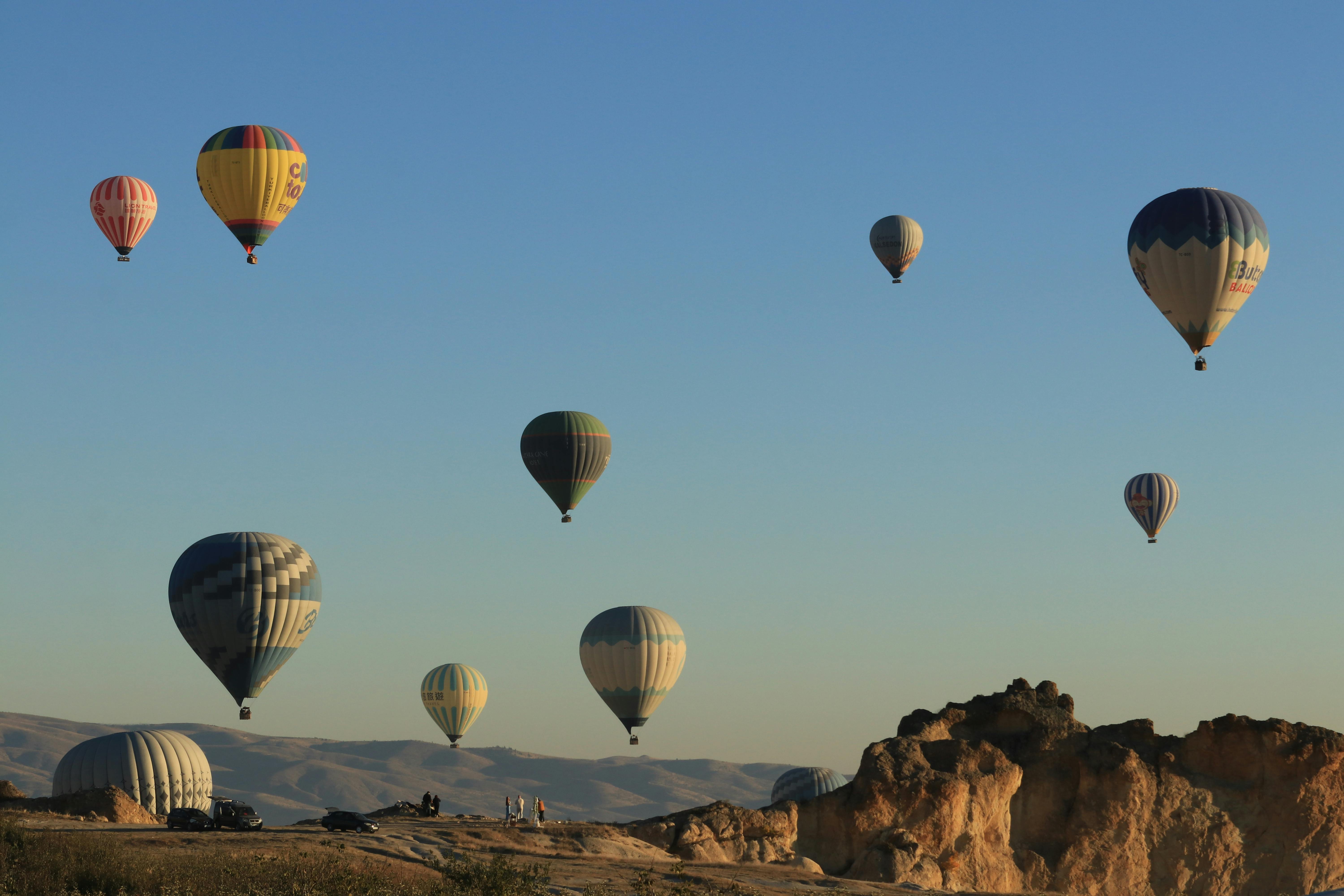Scenic view of hot air balloons soaring over Cappadocia's unique landscape at sunrise.