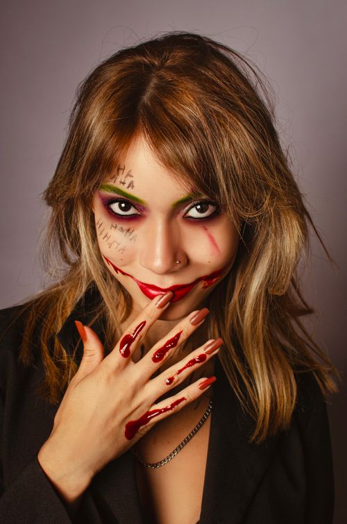 Free Portrait of a woman in vivid Joker-themed Halloween makeup. Stock Photo