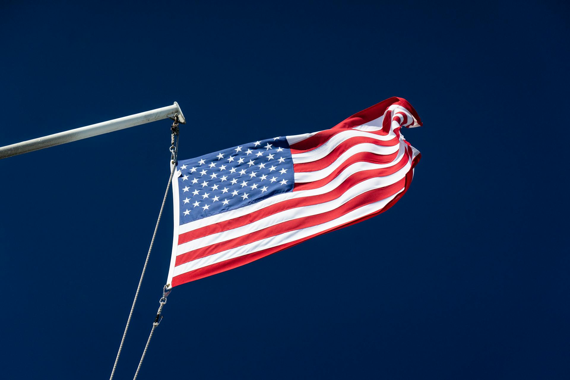 The American flag waving proudly against a clear and vibrant blue sky, symbolizing patriotism.