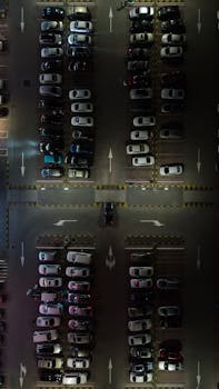Overhead shot of a busy urban parking lot at night with parked cars.
