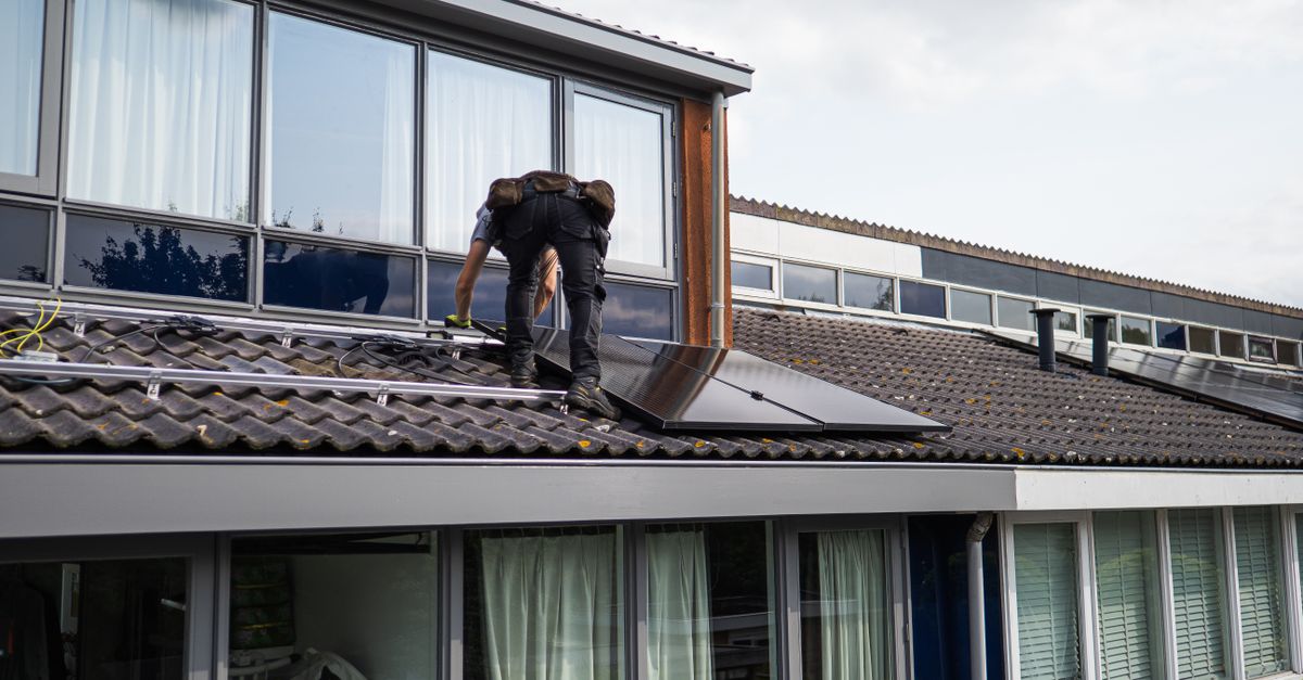 Technician installing solar panels on a residential rooftop