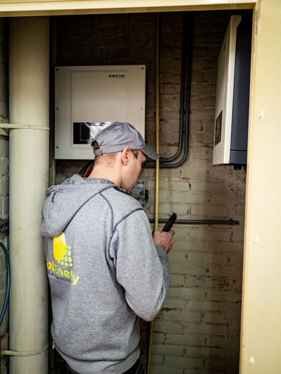 Técnico observa equipos eléctricos de energía solar en interior; foto ilustrativa, no instalación catalana identificada