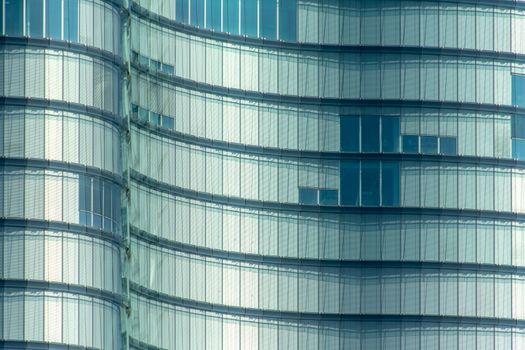 Close-up of a modern glass building facade with curved architecture design.