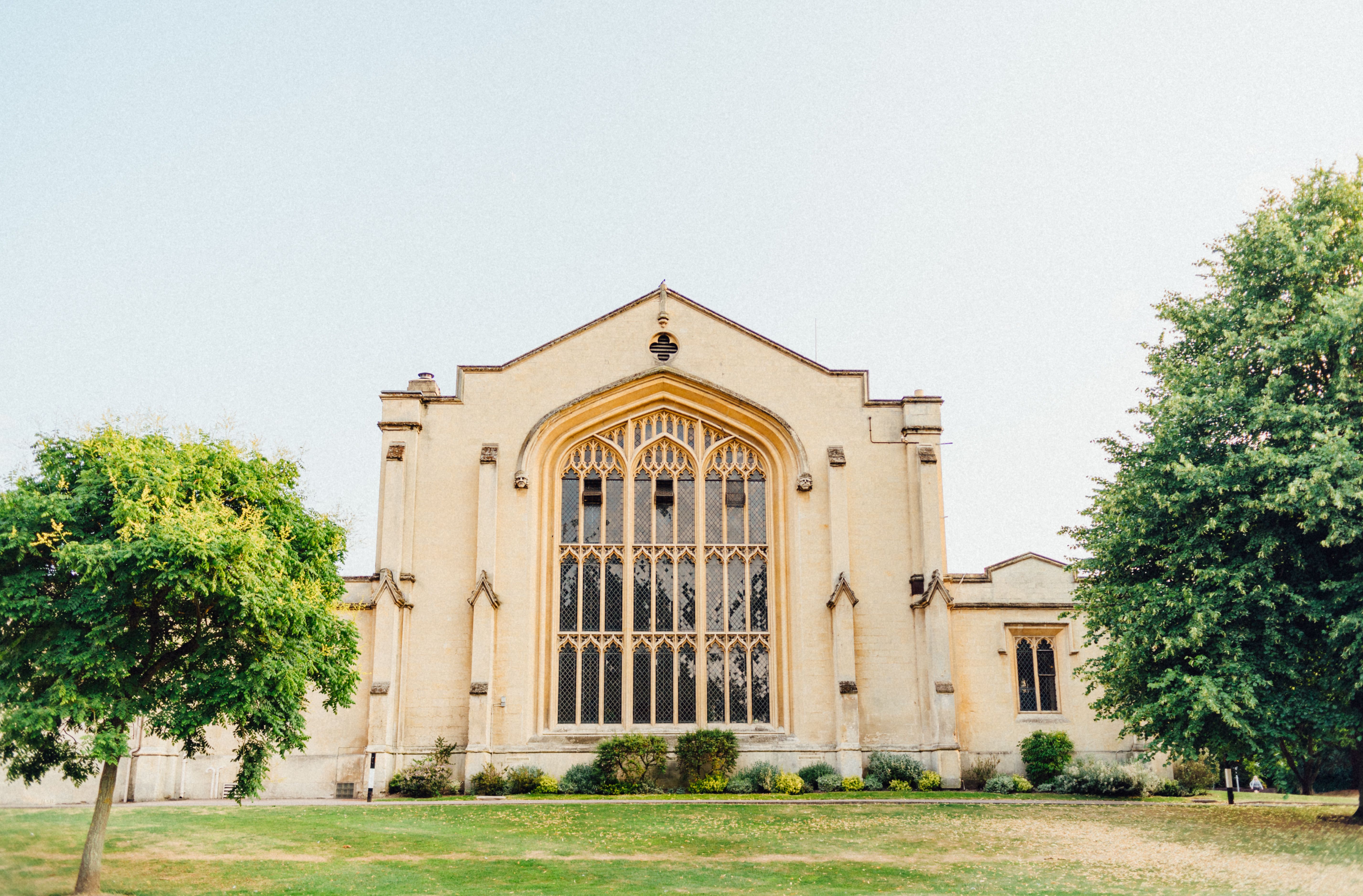 A grand historic church surrounded by greenery, captured in bright daylight.