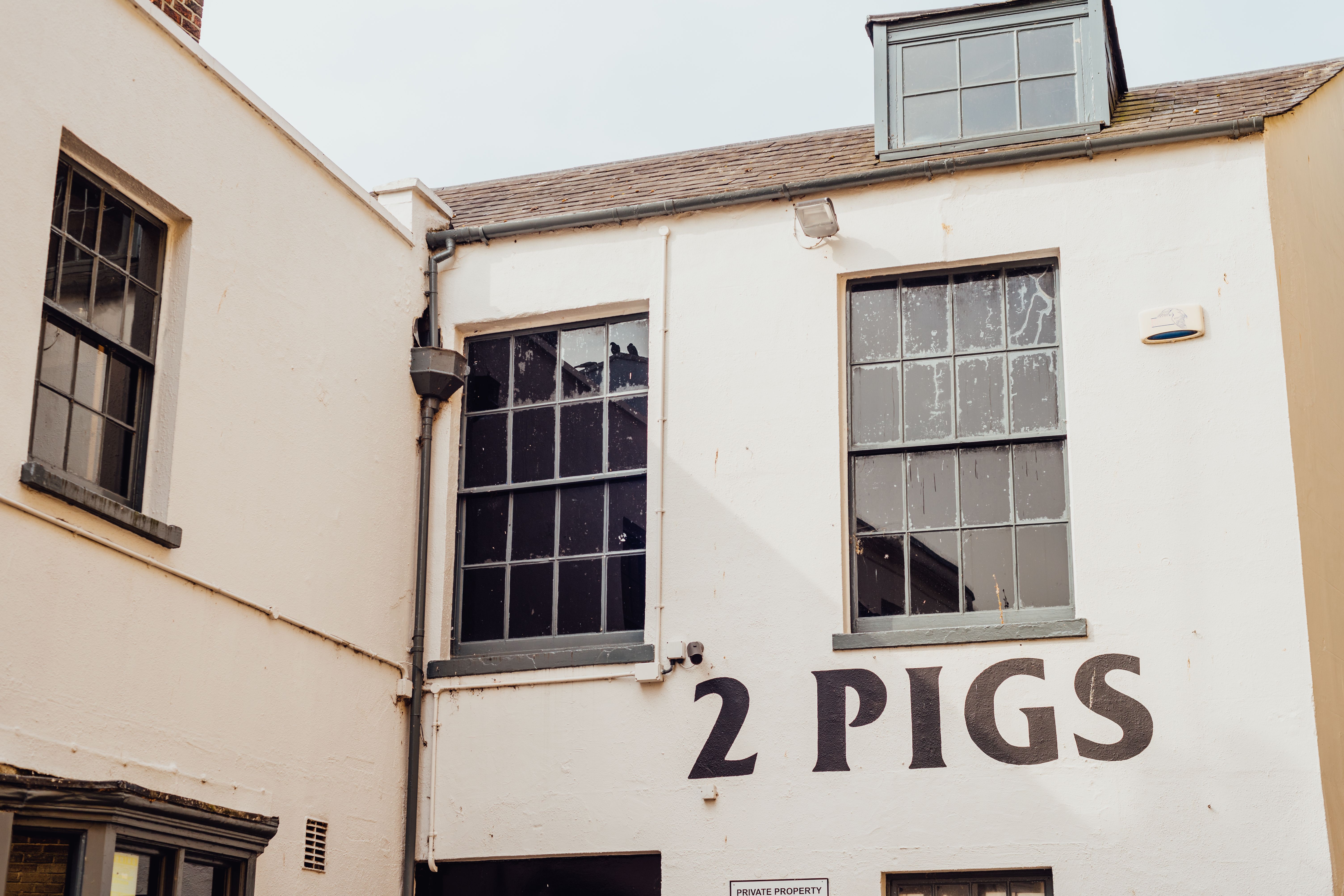 Urban Architecture Featuring '2 Pigs' Sign · Free Stock Photo