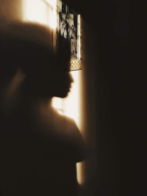 Shadow of person on wall in sunlight, creating a dramatic and artistic silhouette.