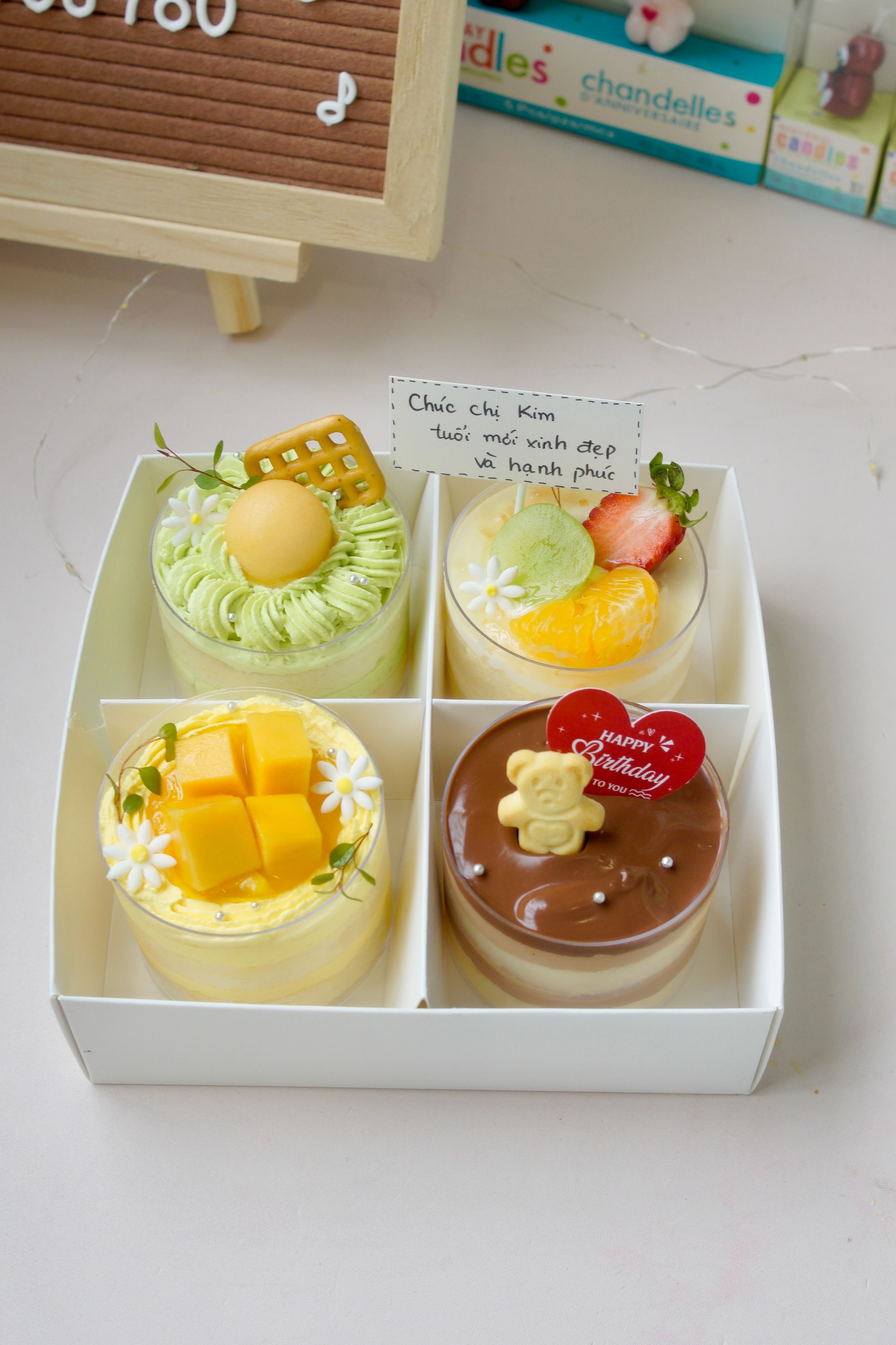 Boxed set of four decorated mini cakes