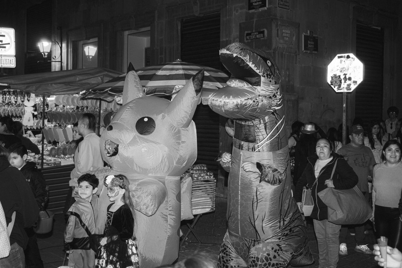 black and white photo of people in inflatable costumes during a nightt