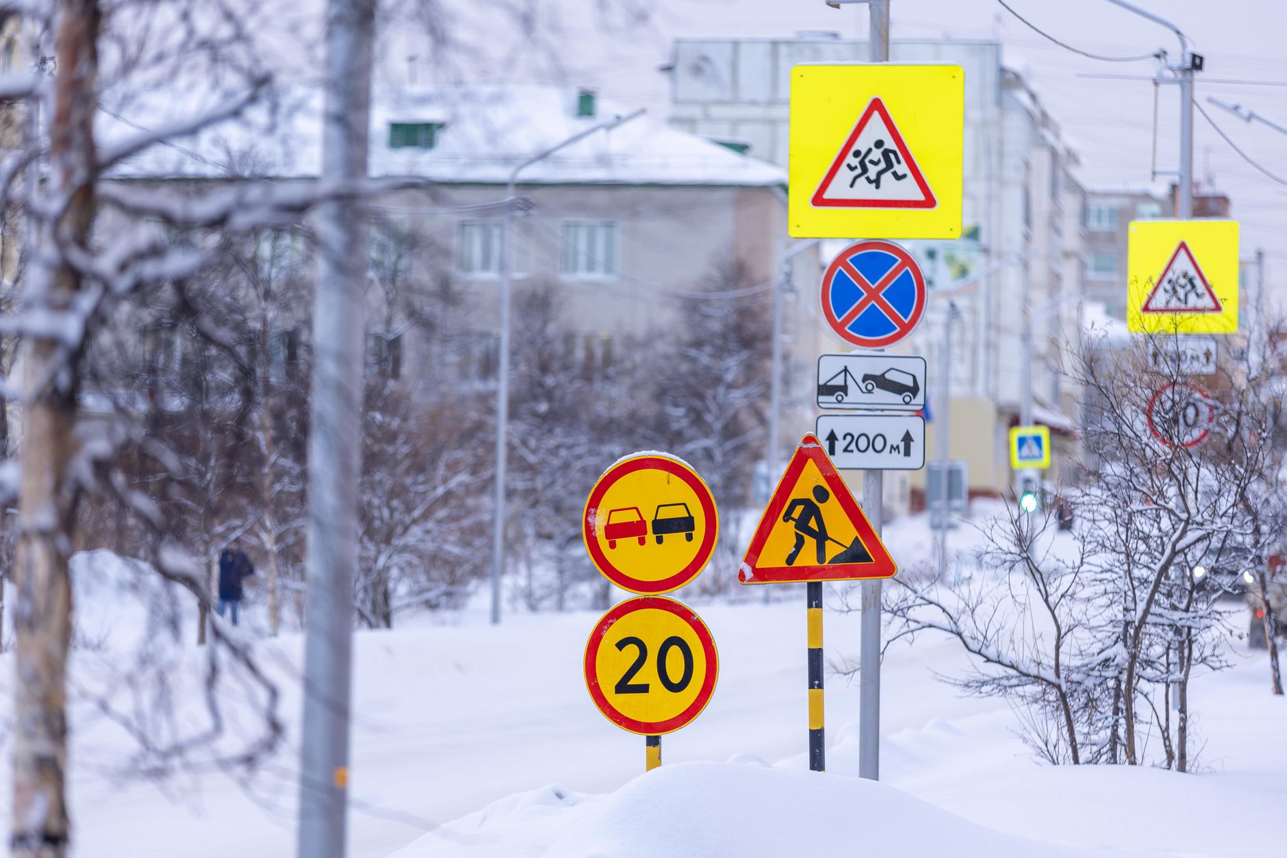 Colorful traffic signs in a snowy city street during winter.